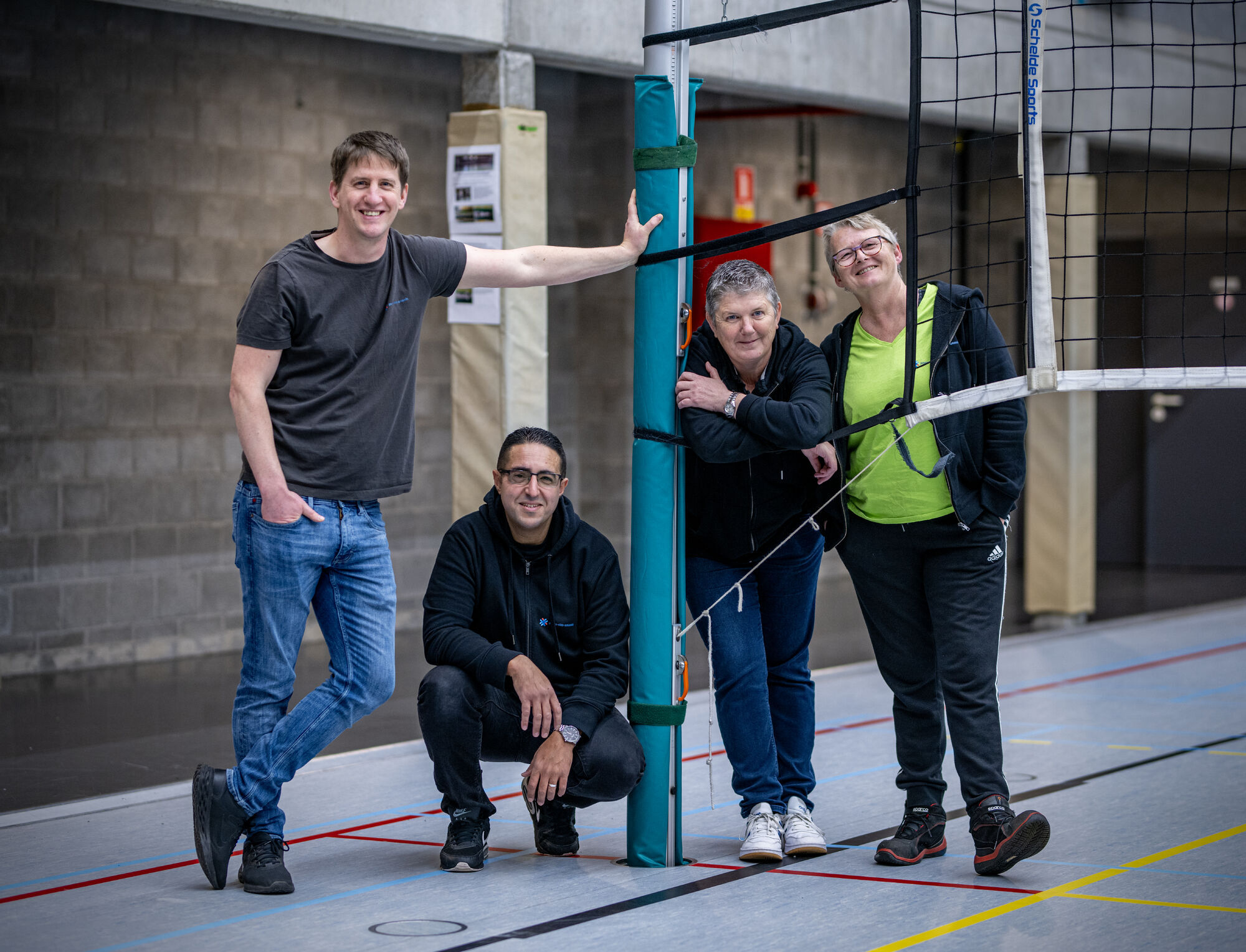 Vier zaalwachters van gemeente Puurs-Sint-Amands poseren in de sporthal
